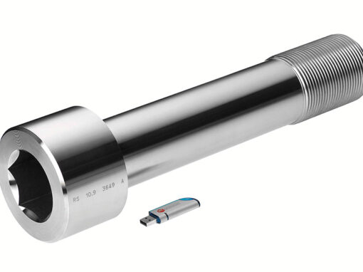 warmformteile-schmiedeteile-03 Große, metallische Schraube neben USB-Stick zur Größenveranschaulichung, industrielles Verbindungselement.