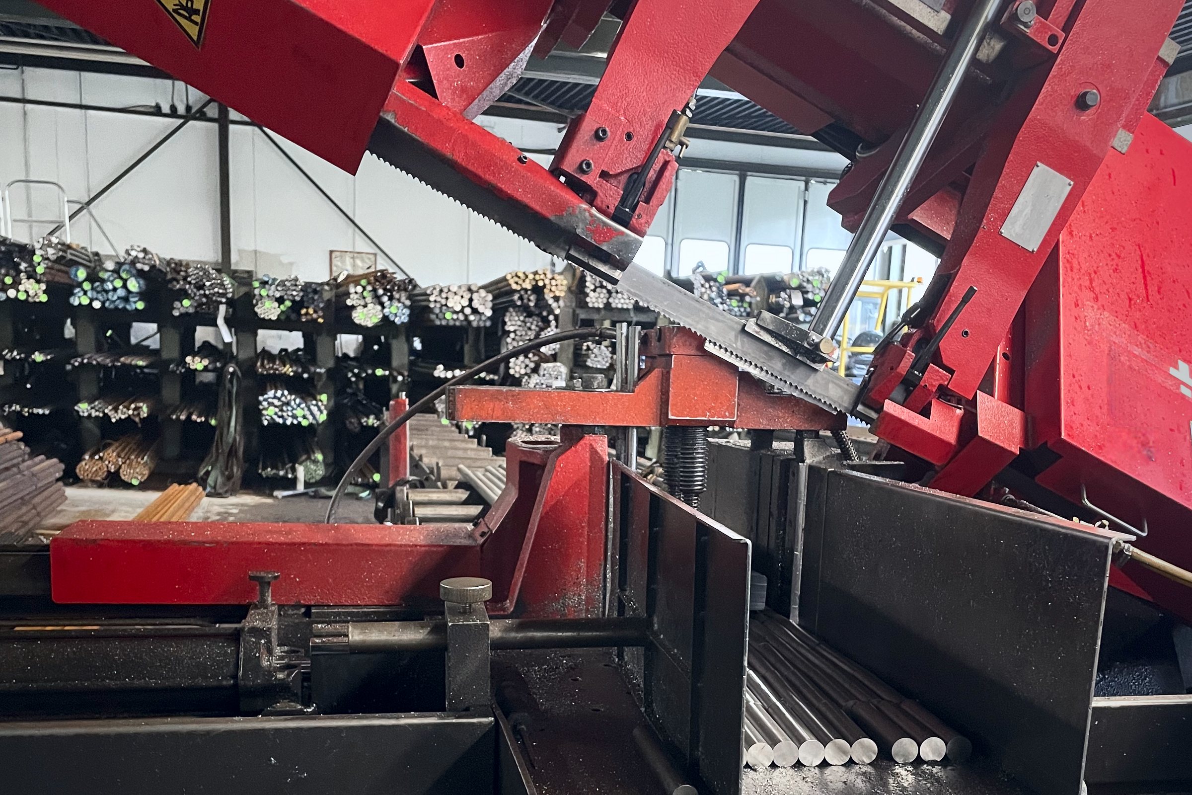 Band saw in operation, sawn billets on the rack