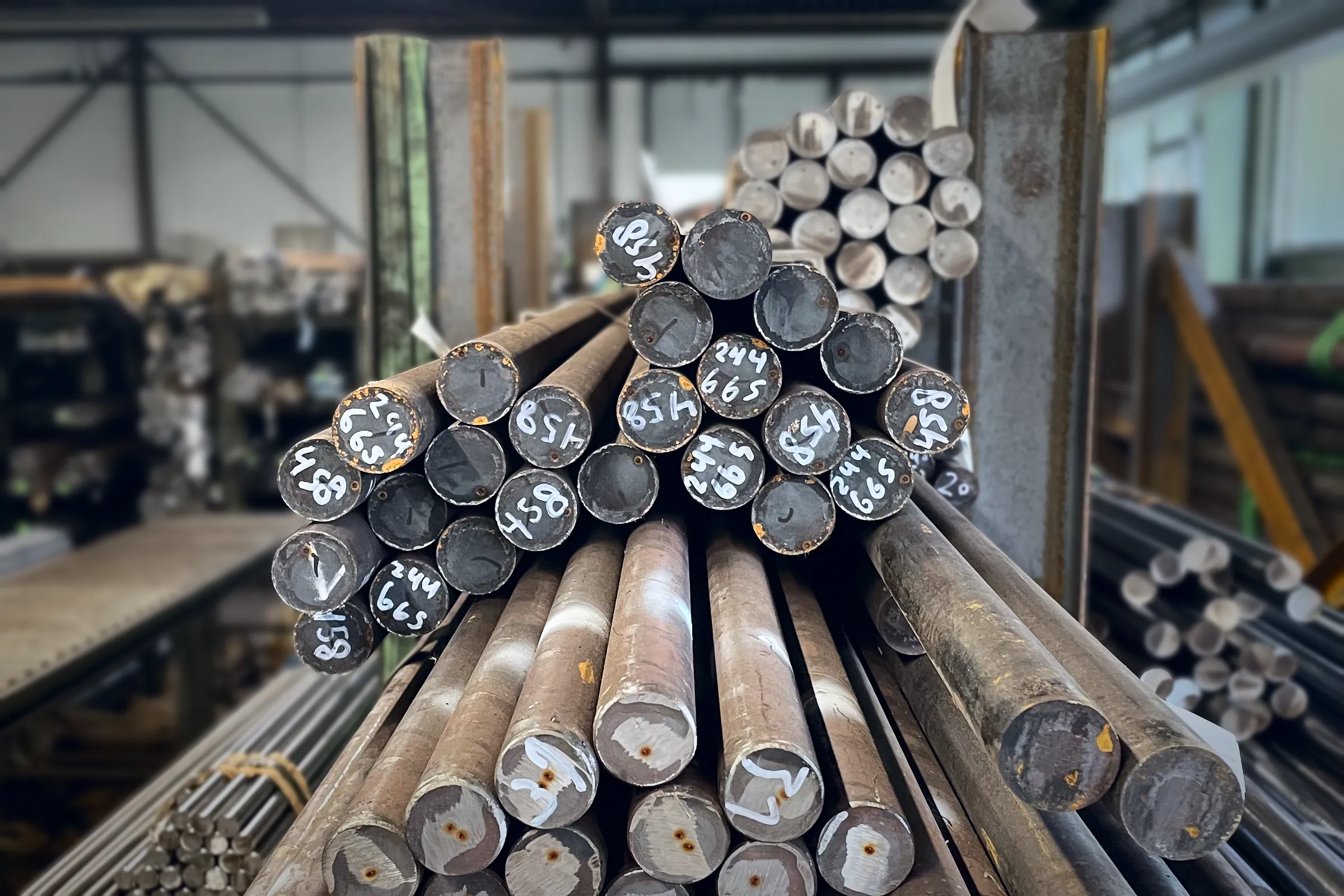Bund aus Stahlstangen mit beschrifteten Stirnseiten im Materiallager